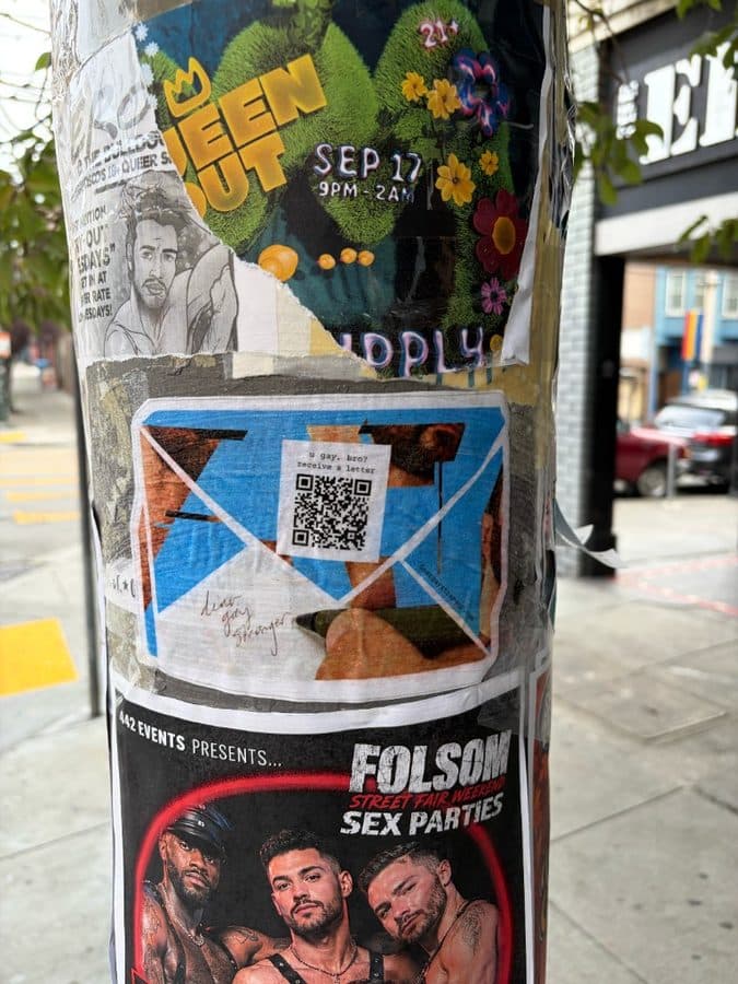 Dear Gay Stranger sticker among flyers on a city pole