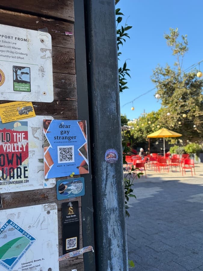 Dear Gay Stranger flyer pinned to an outdoor recreation board