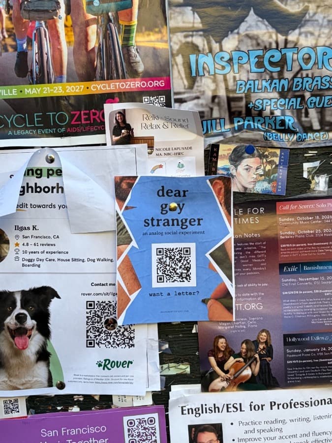 Dear Gay Stranger flyer among posters on a crowded community board